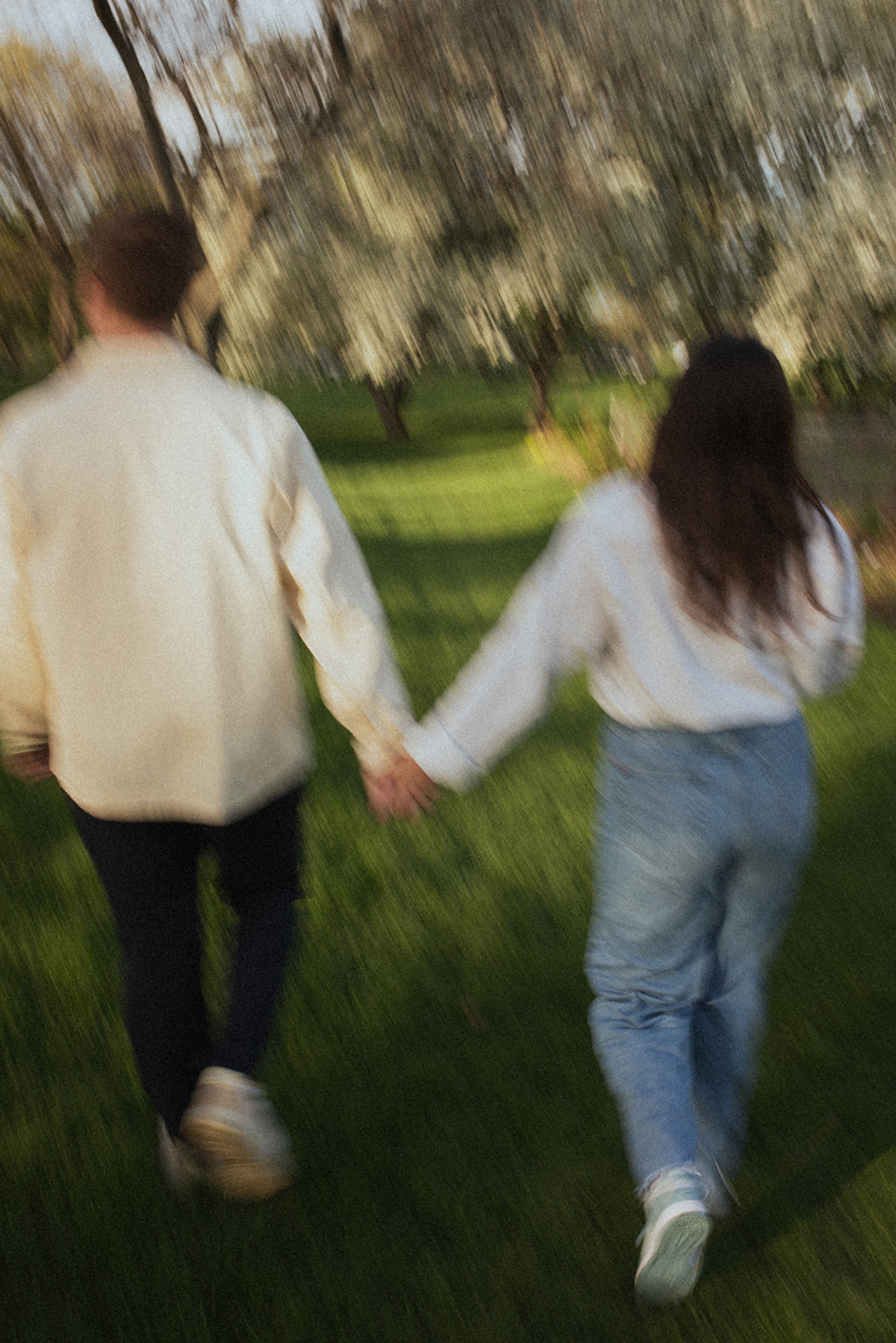 motion blur photo of couple walking together holding hands through a garden