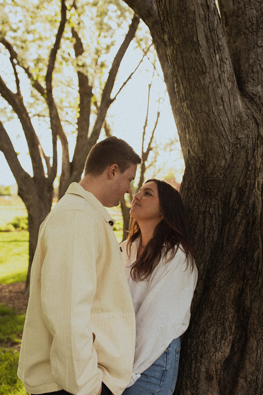 romantic couple leaning against a tree 