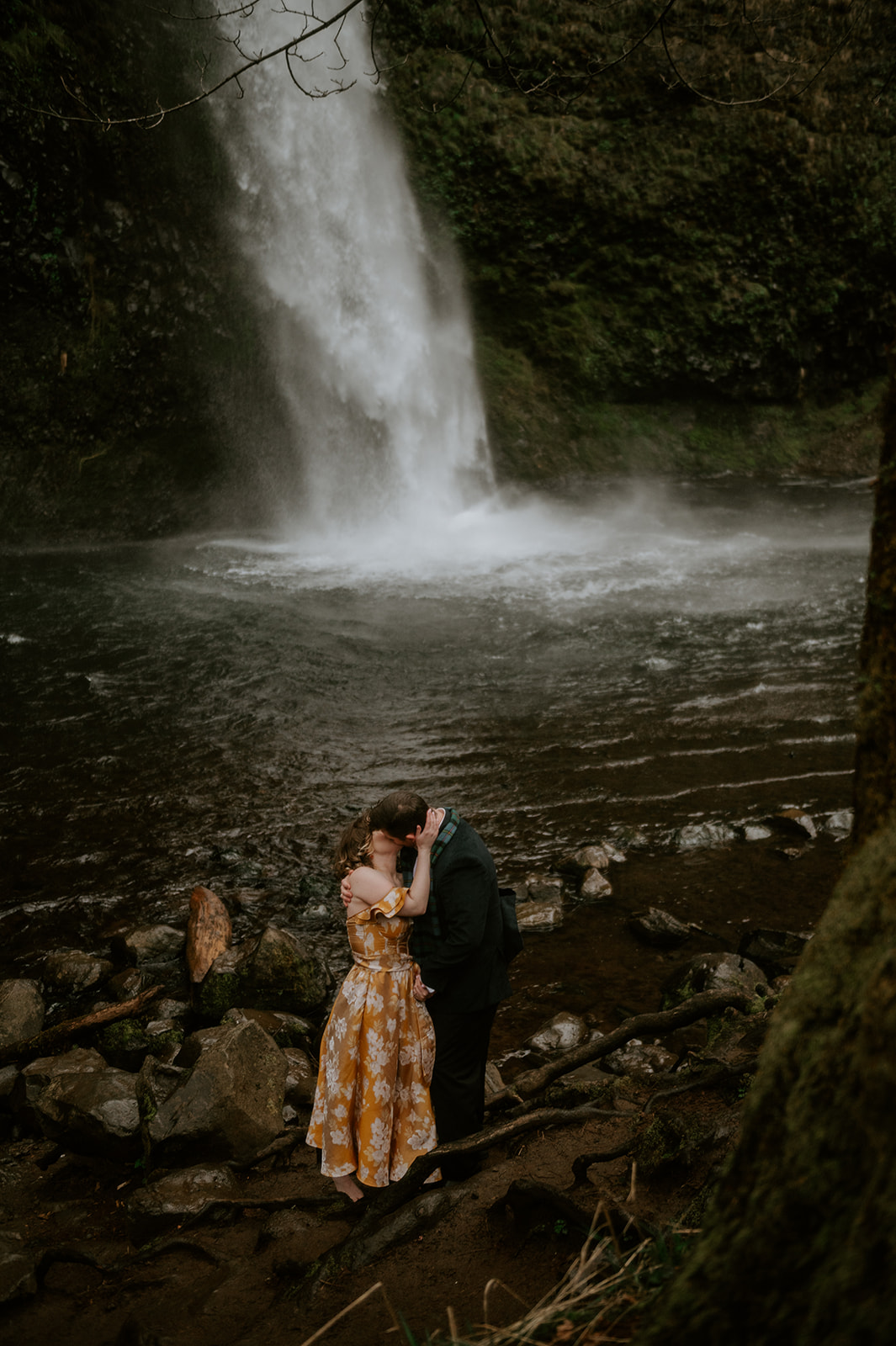 A couple kissing at the base of a portland oregon waterfall 