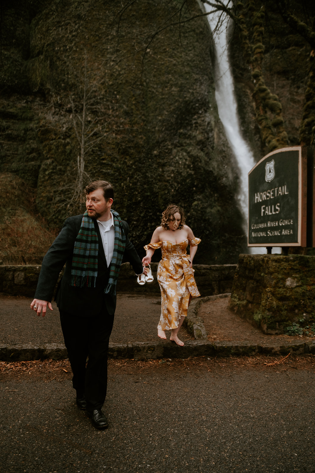 A couple walking across the street dressed in formal clothes at horsetail falls