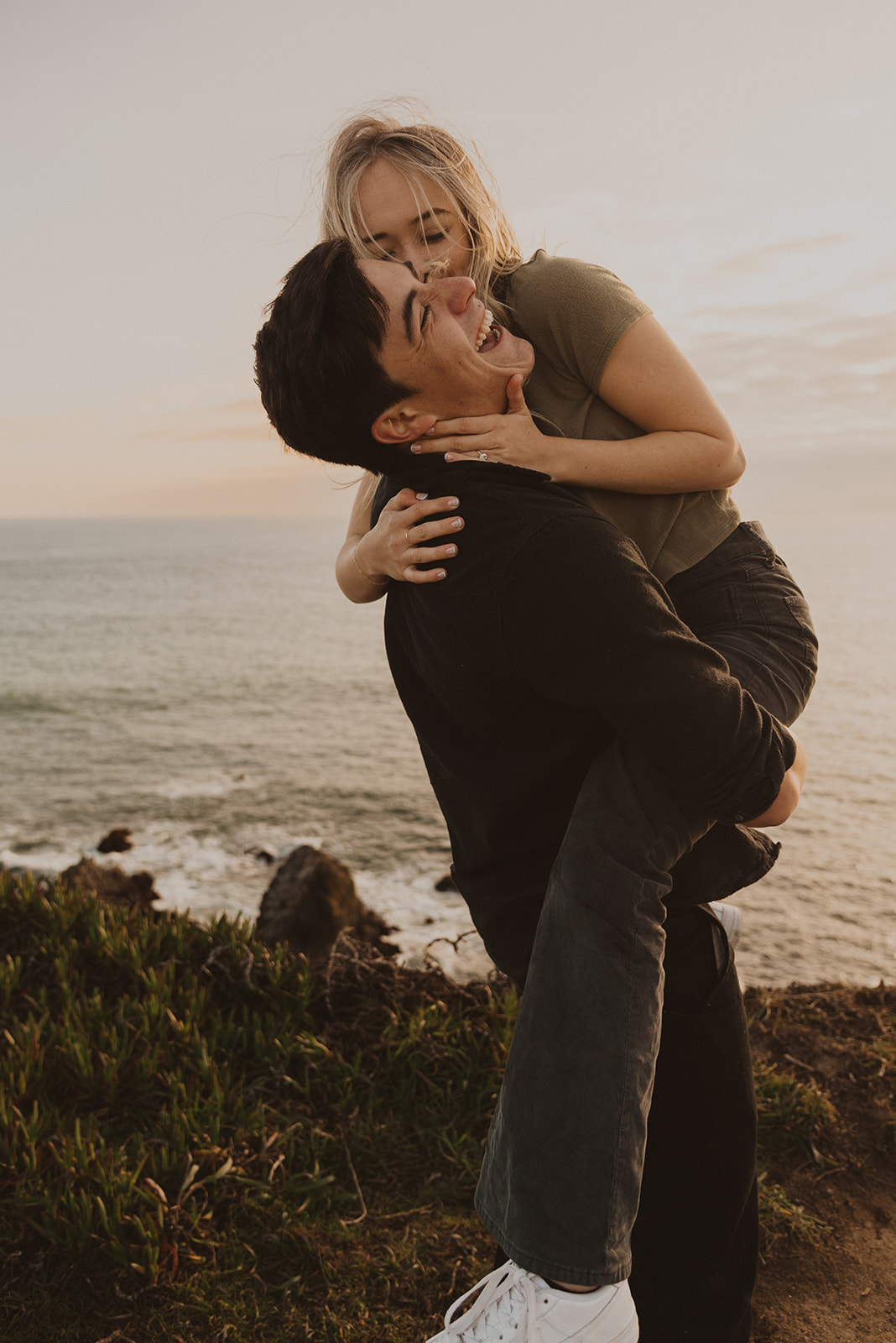 A couple who just got engaged celebrates on the coast of California