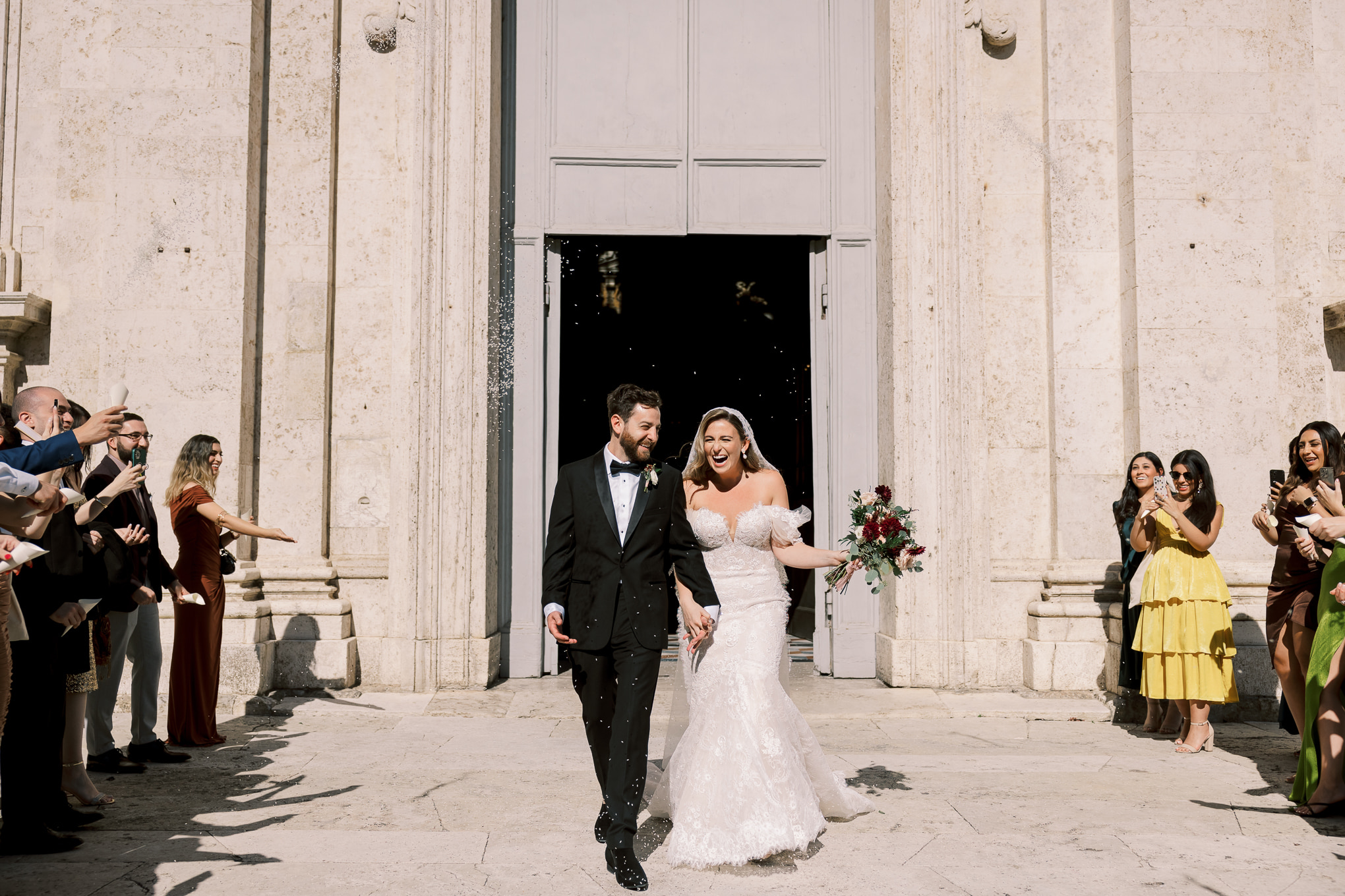 bride and groom walk out of church during italy wedding