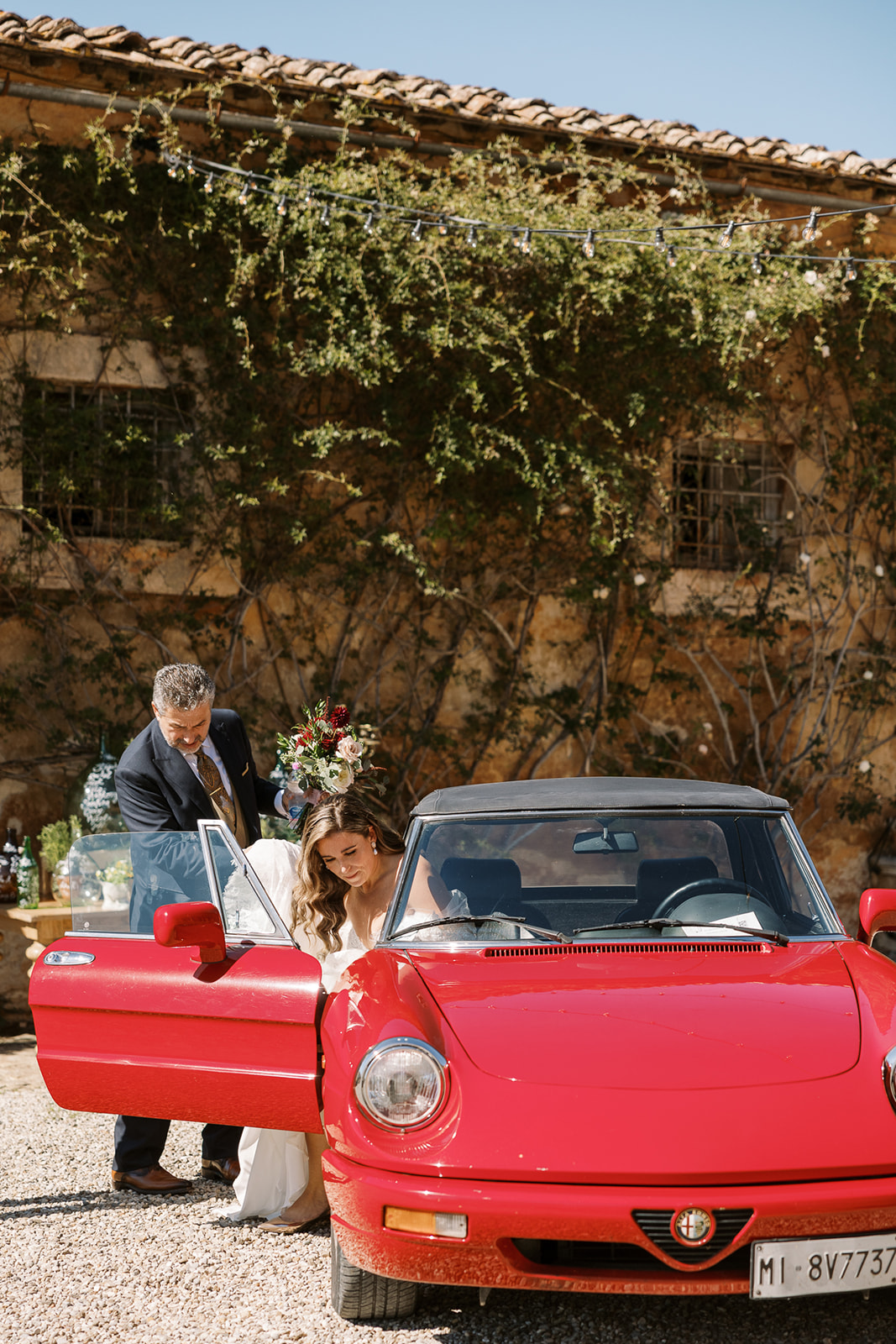brides gets into red sports car
