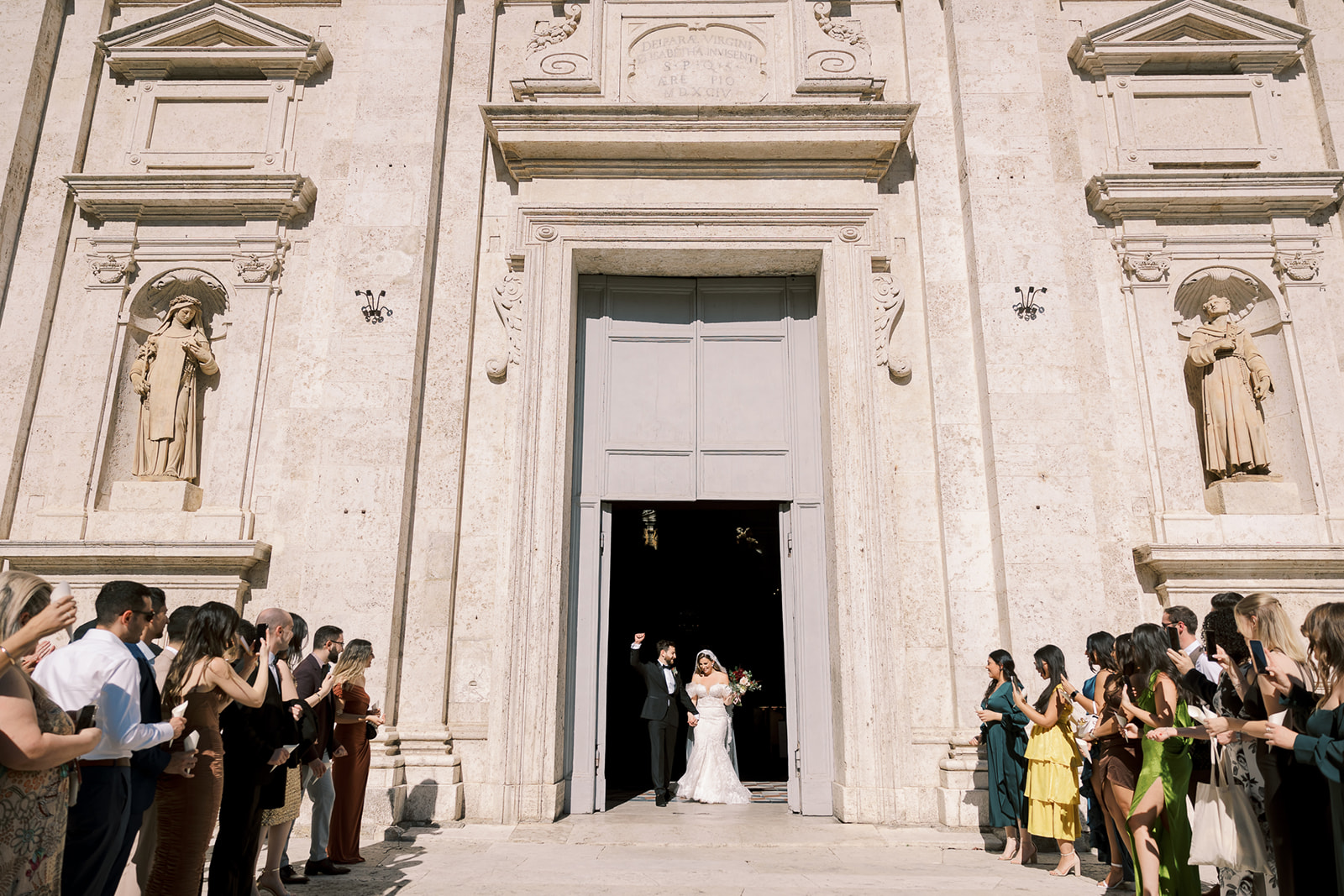 bride and groom walk out of church in Siena, Italy