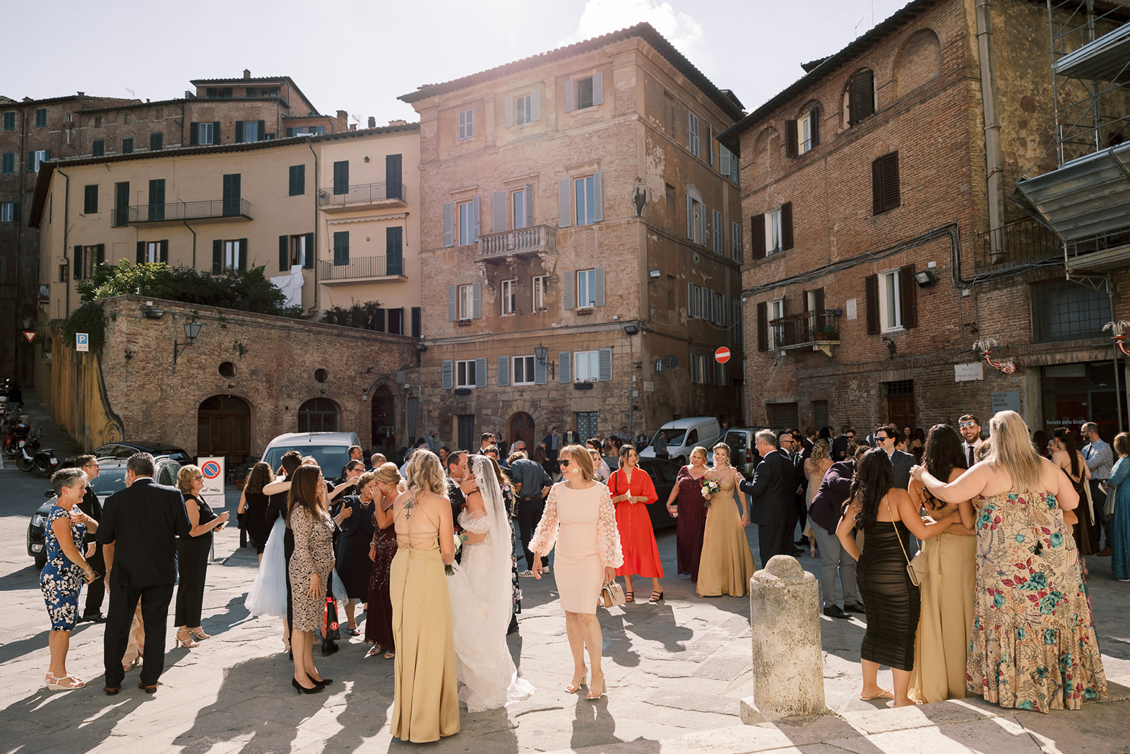 Reception guests stand amongst Italian buildings