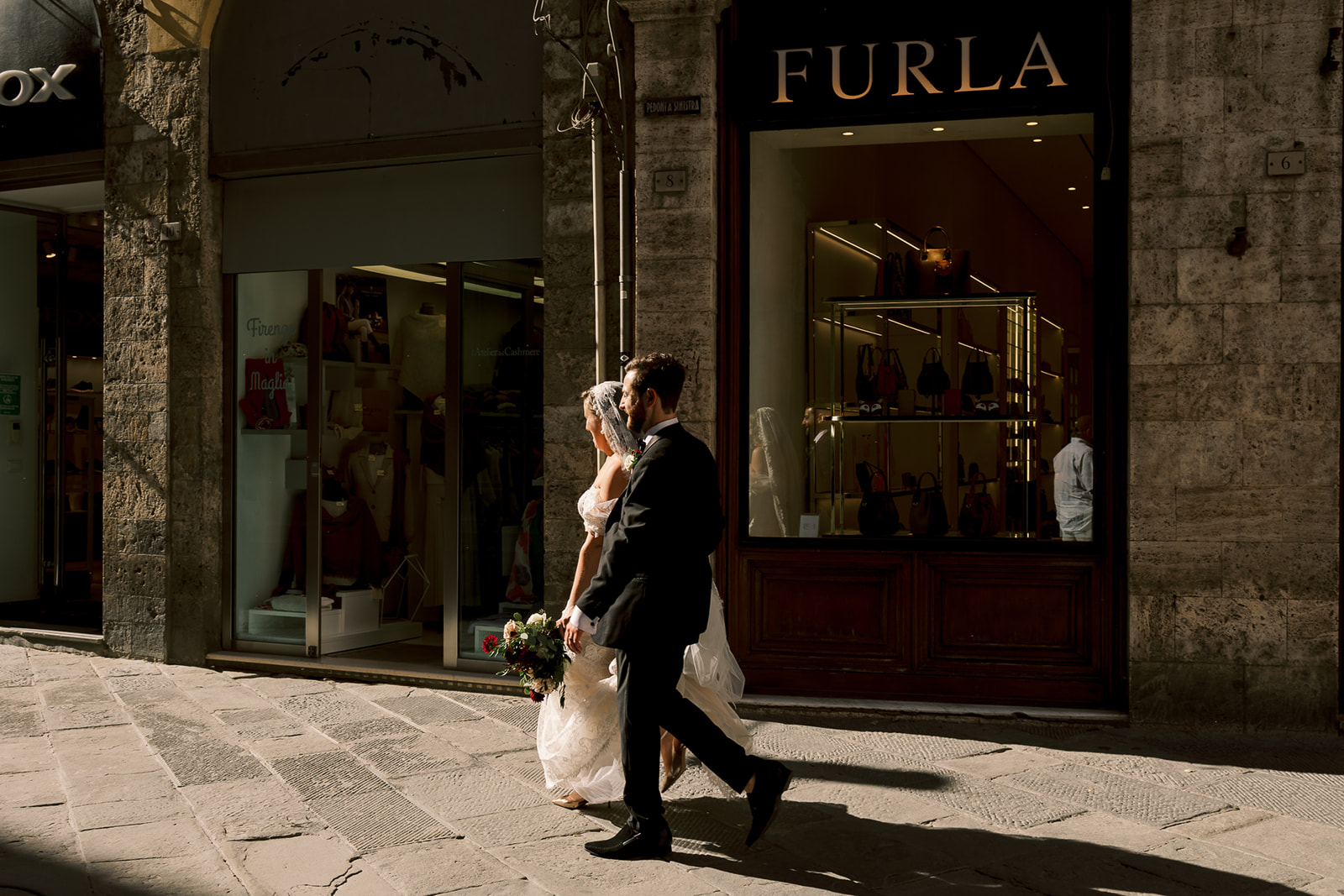 bride and groom walk Italian streets in Siena, Italy