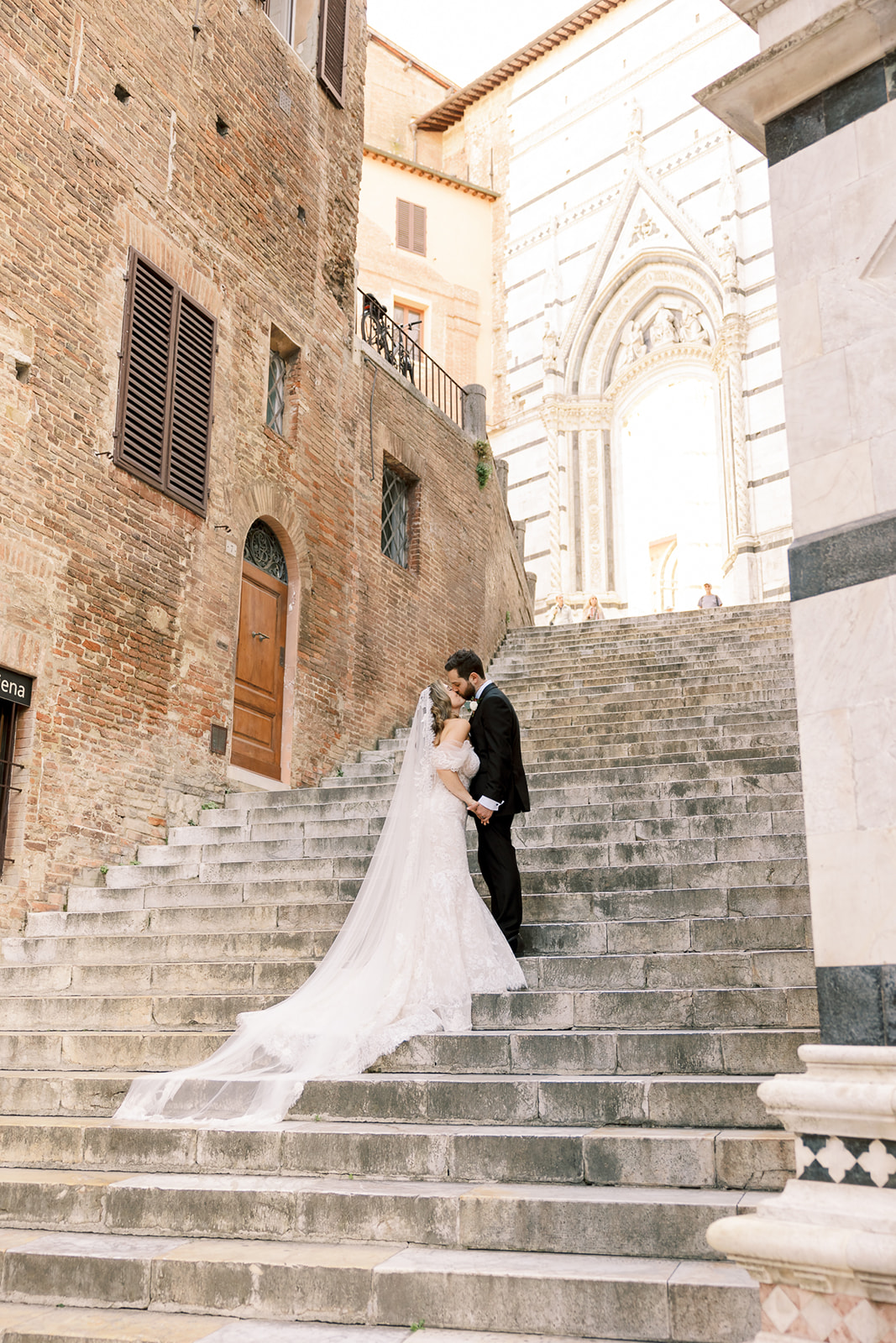 bride and groom pose on Italian steps in Siena, Italy