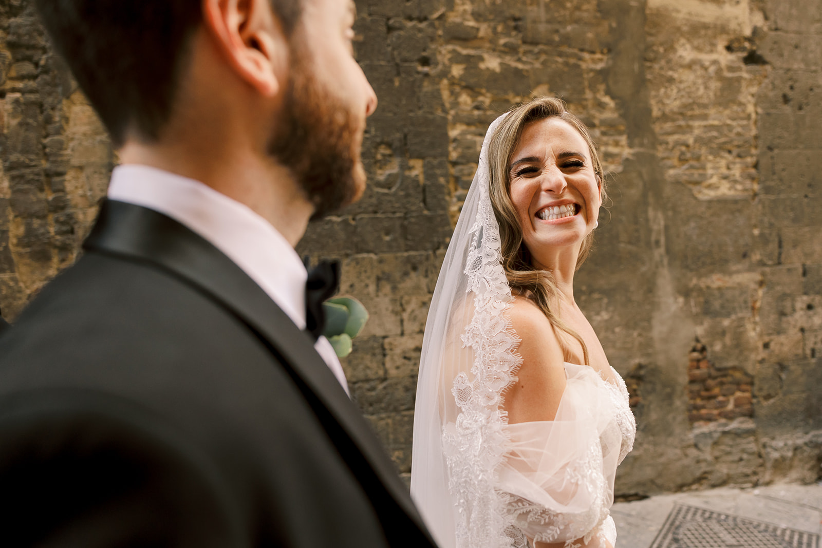 bride smiles at groom as they walk Italian streets