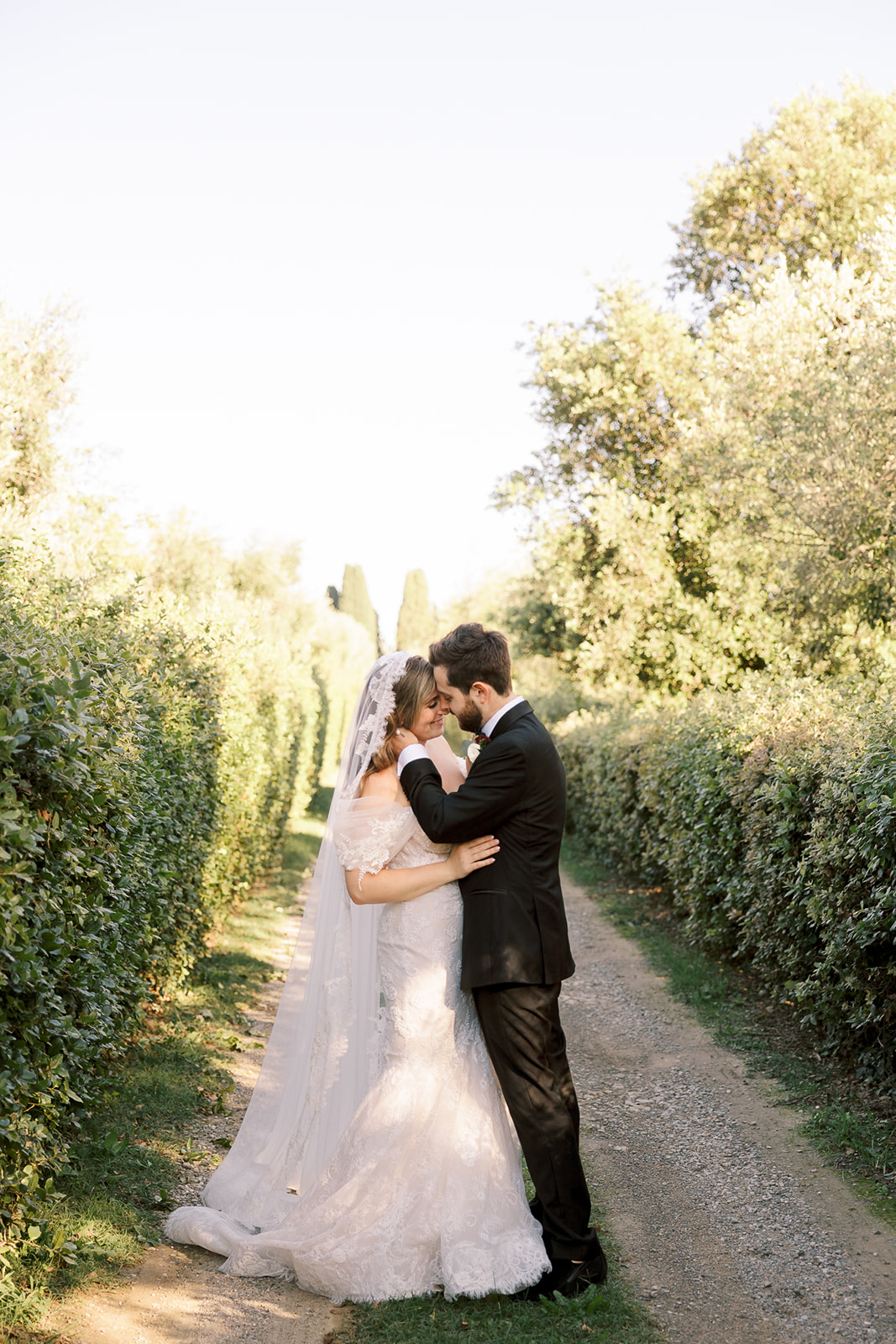 bride and groom kiss in Italian gardens