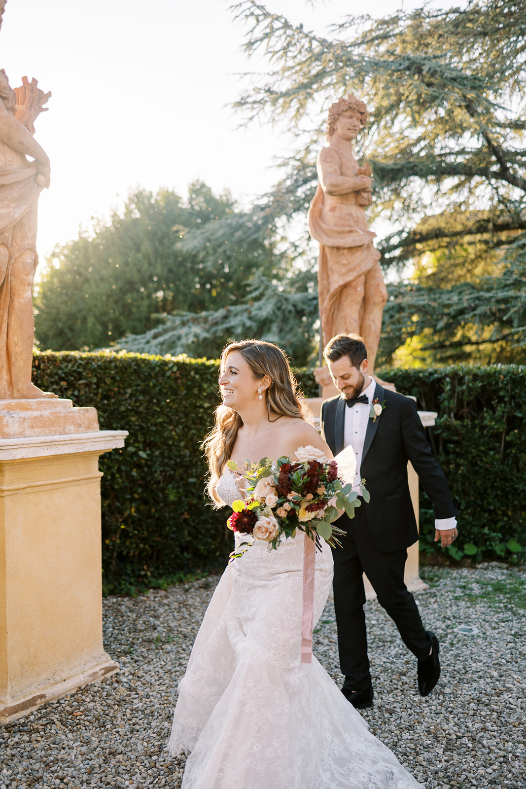 bride and groom walk through Italian gardens