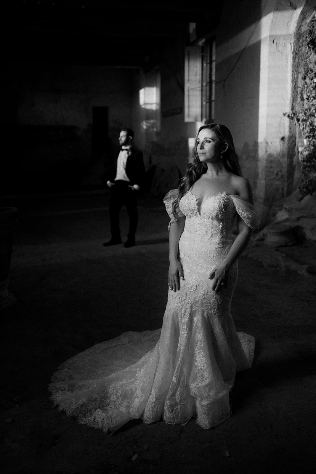 bride and groom stand in ruins with harsh light