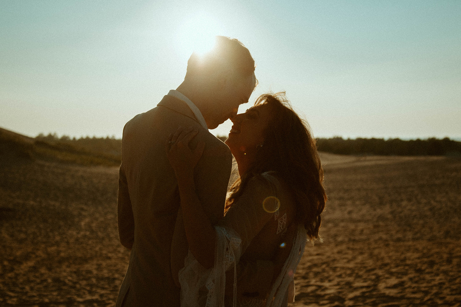 Couple who had bridal photos at the dunes share a kiss.