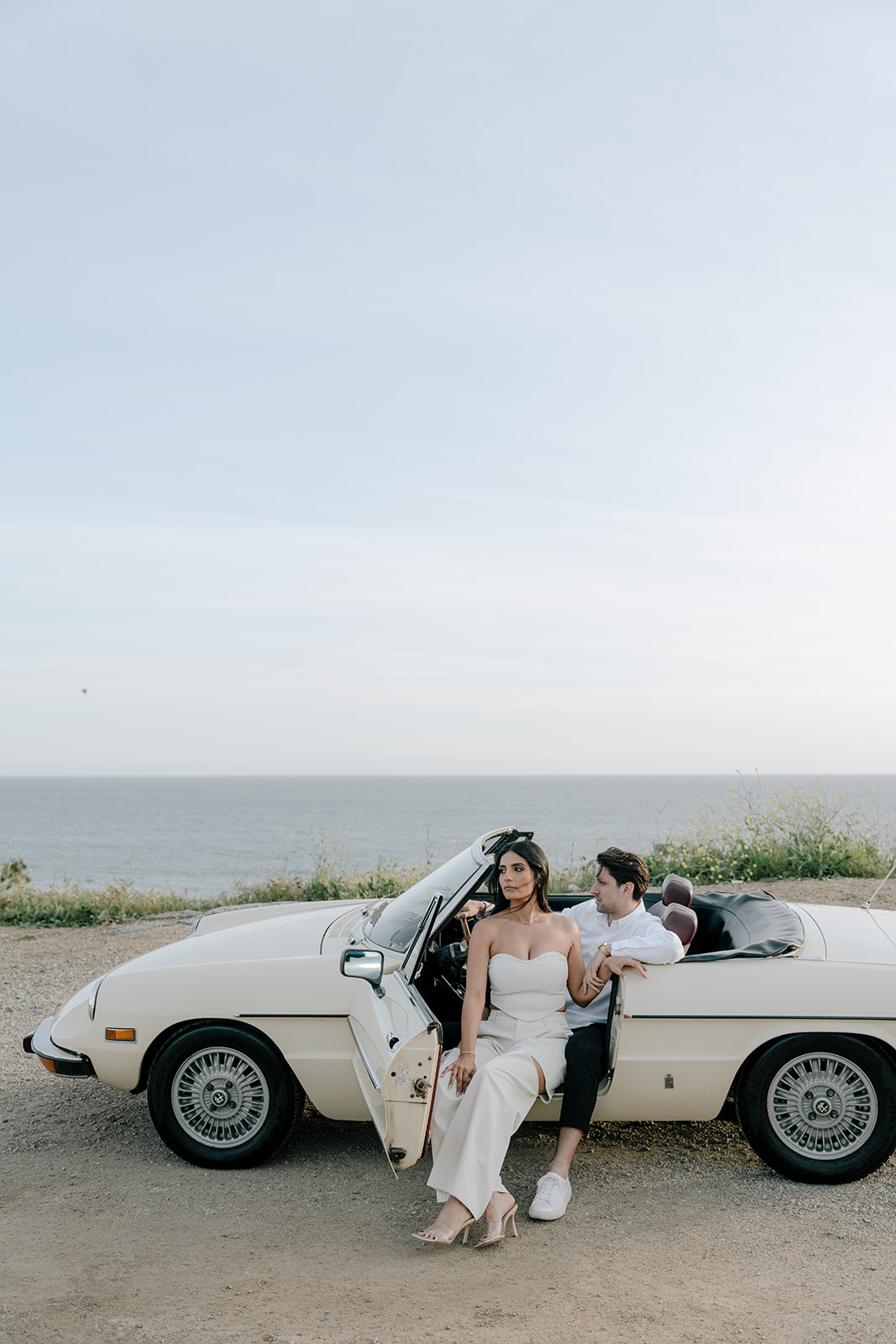 A couple poses inside a vintage car in Malibu.