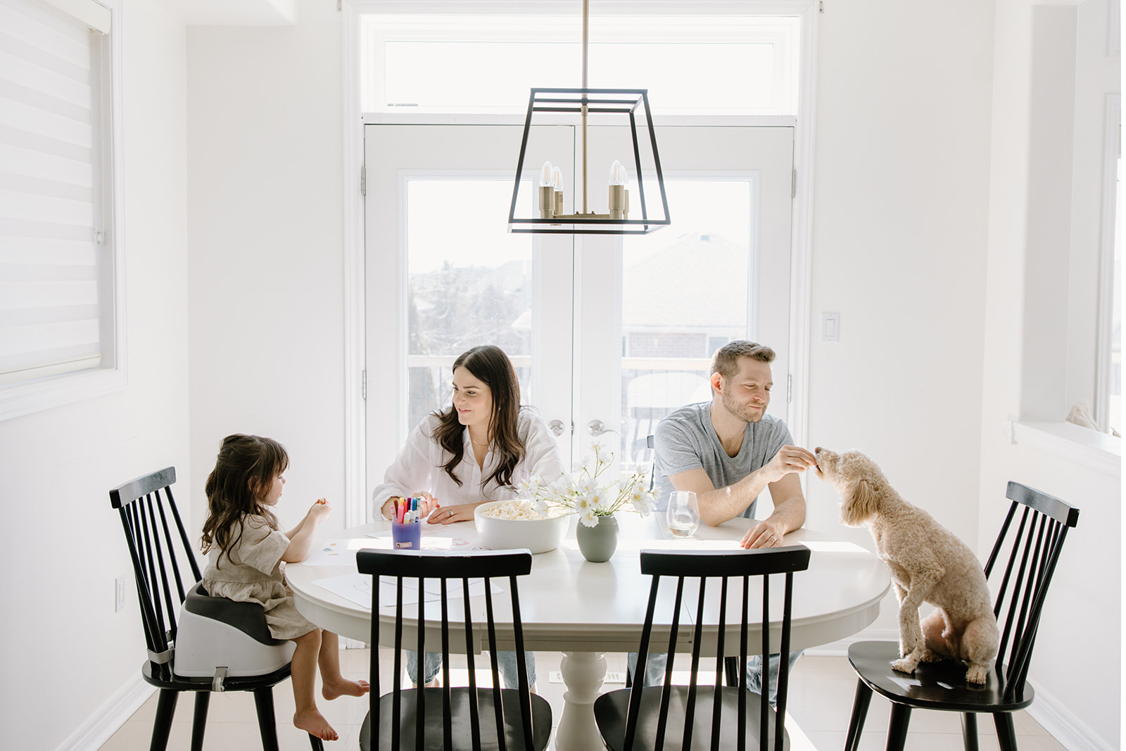 Family shares pizza and popcorn during their at-home family photoshoot in Toronto, Ontario
