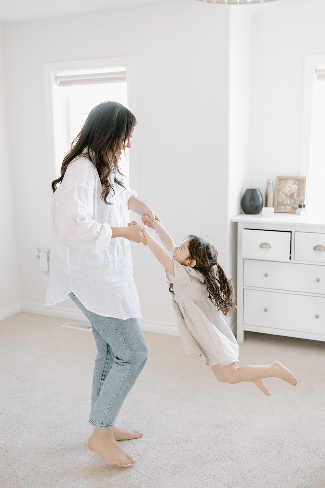 Mom and Daughter swing around during at-home family photoshoot in Toronto, Ontario