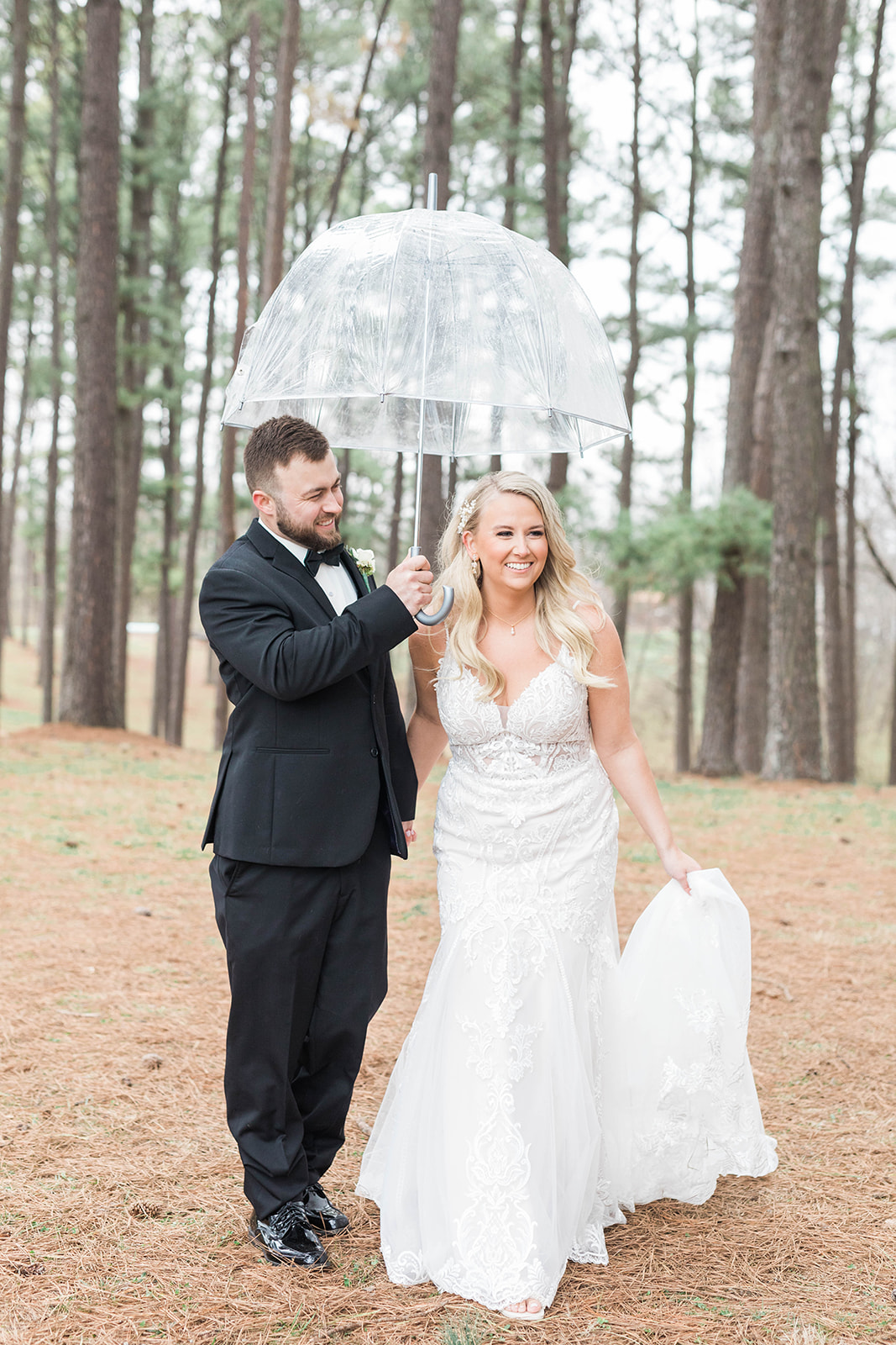 Bride and groom with umbrella on rainy wedding day