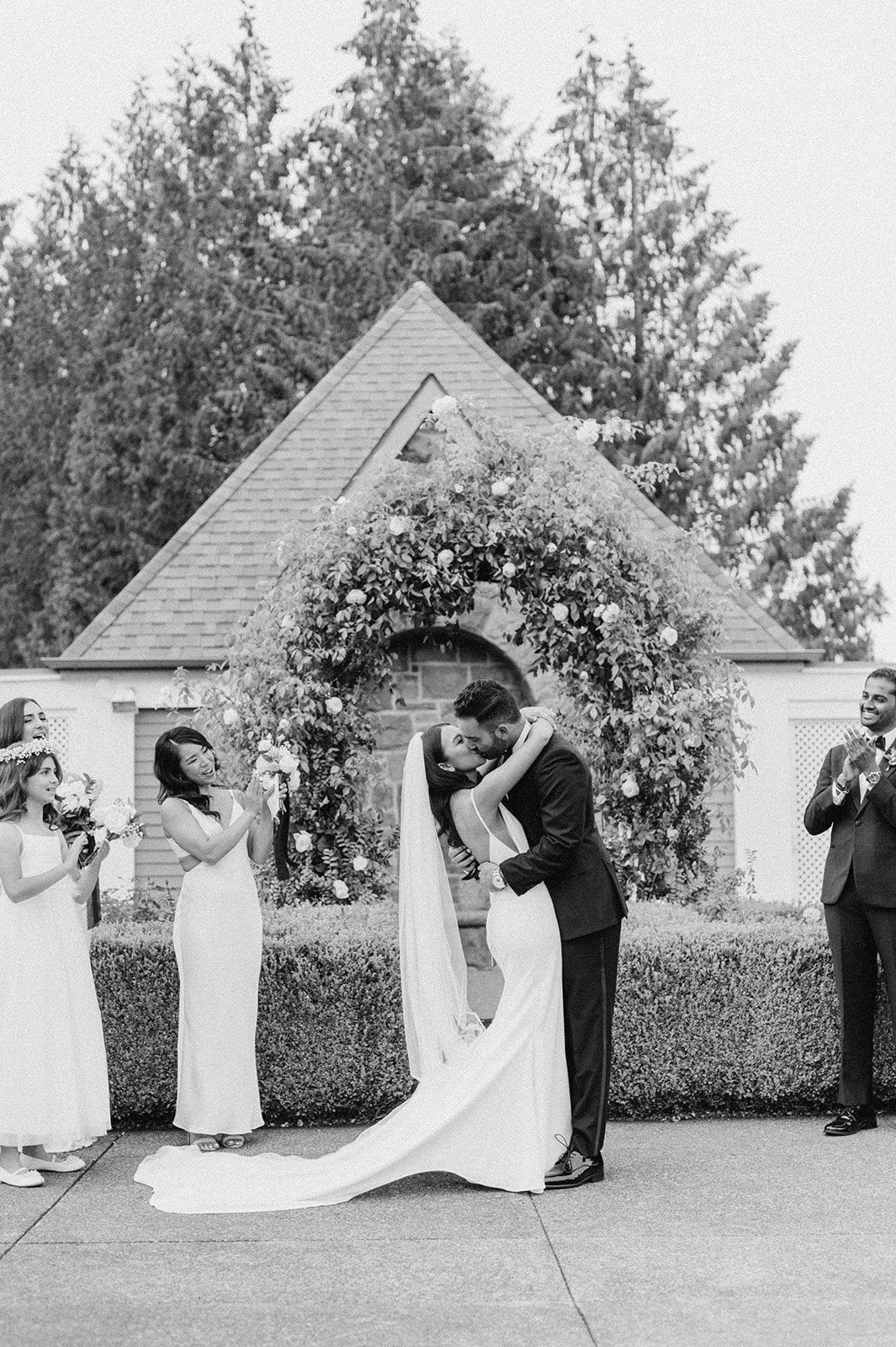 Black and white photo of bride and groom kissing after being pronounced married