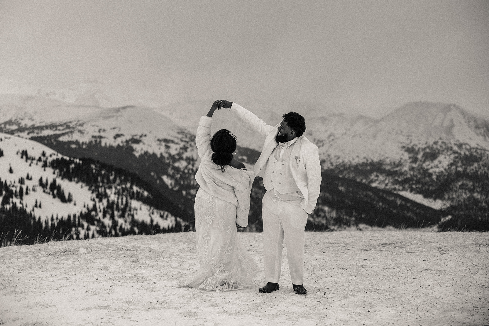 Man dancing with woman playfully during their snowy anniversary session 