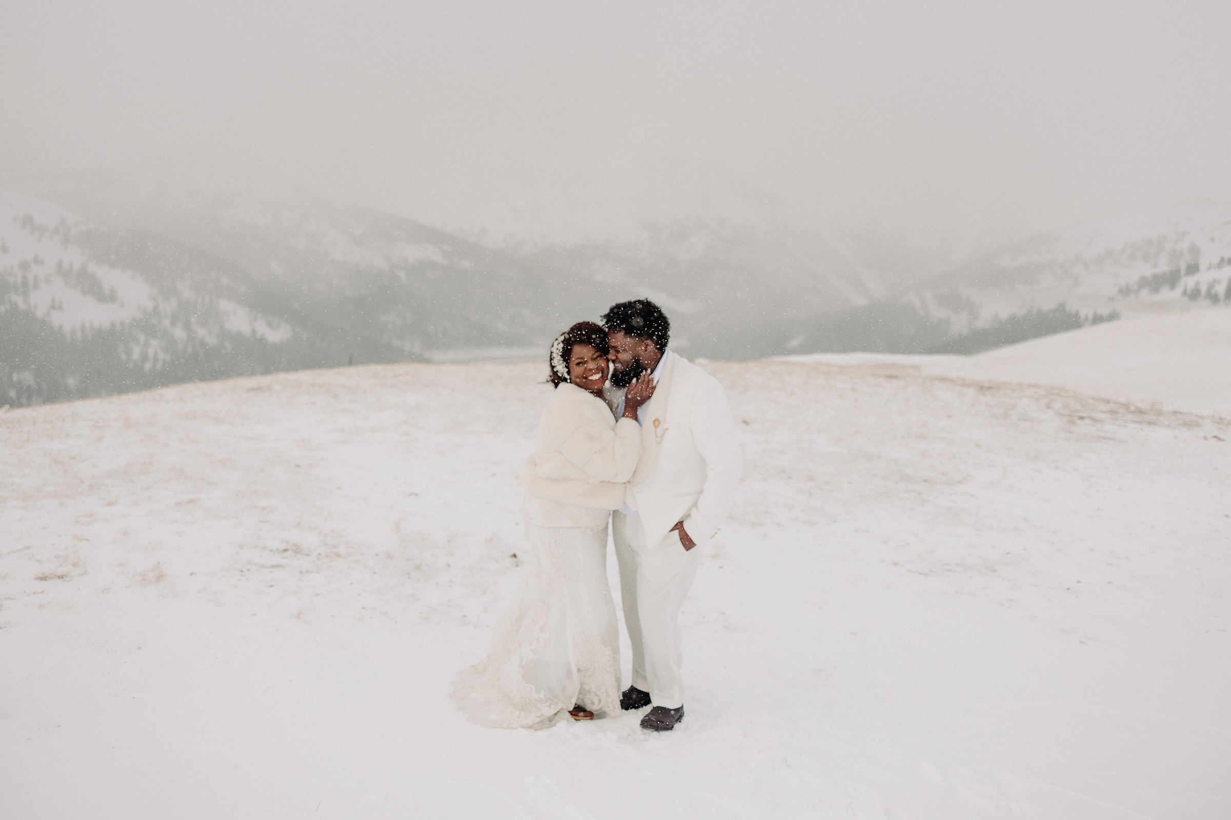 Husband kissing his wife during their snowy anniversary session 