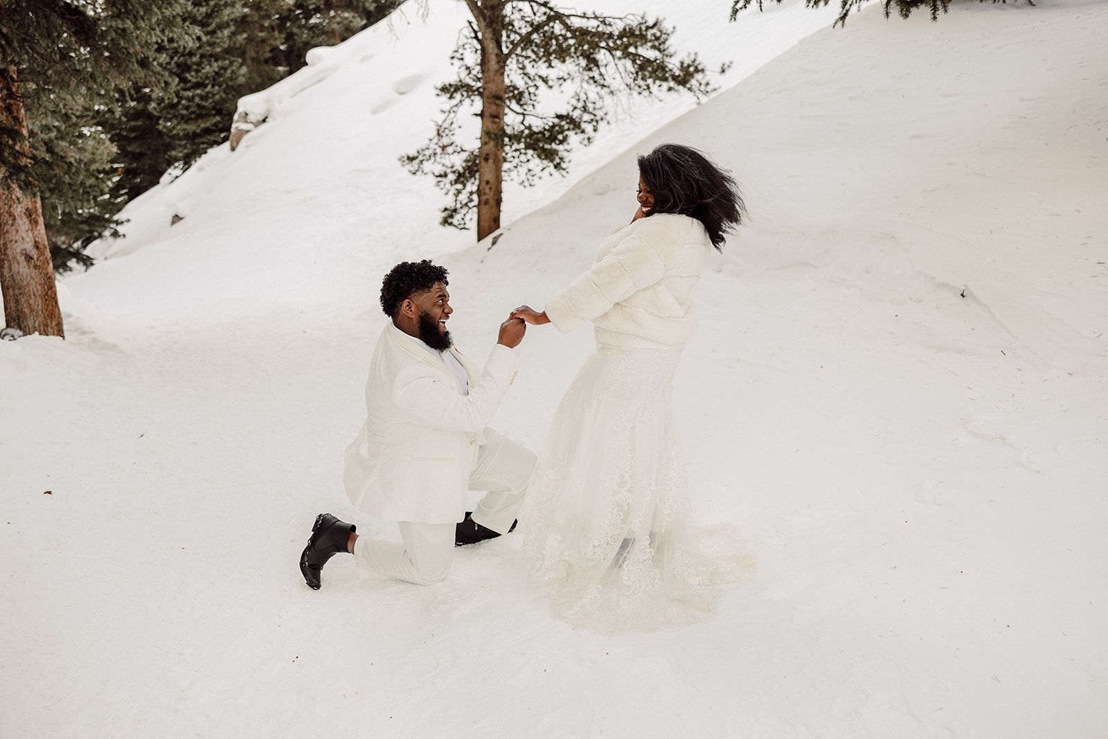 Peterson proposing to Frances playfully during their snowy anniversary session 