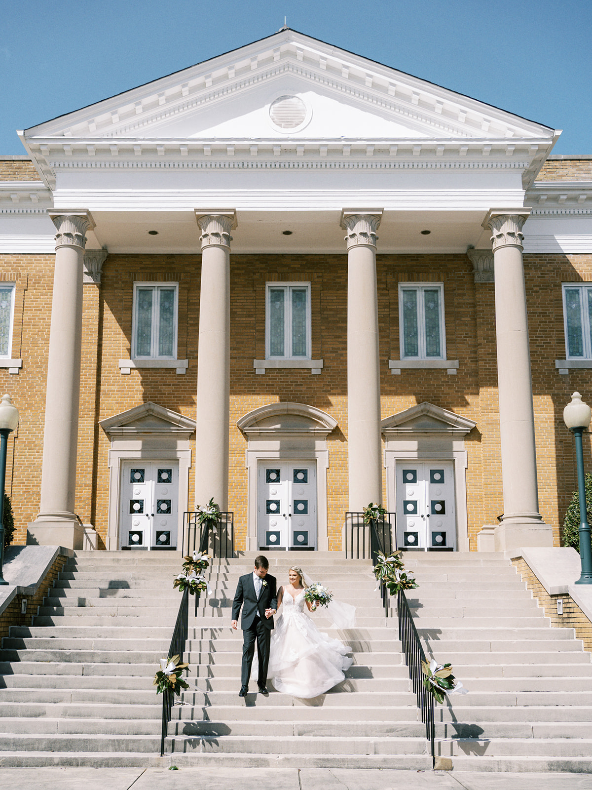 The bride and groom walk down the steps at First United Methodist Church in Athens, Alabama