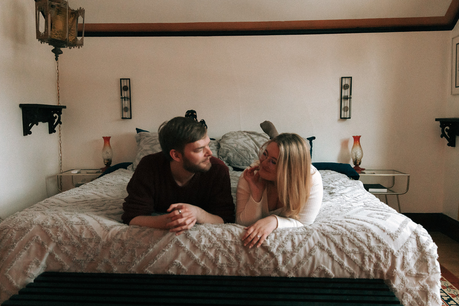 Engagement pictures on the bed in a cute Milwaukee airbnb