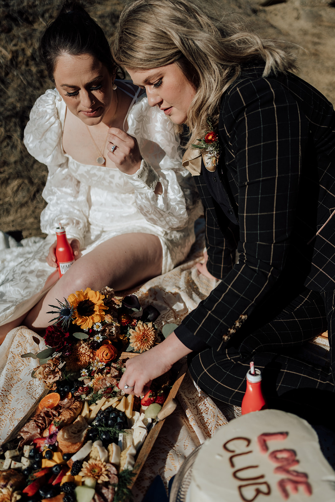 couple shares charcuterie and cake after their southern alberta elopement at writing on stone provincial park