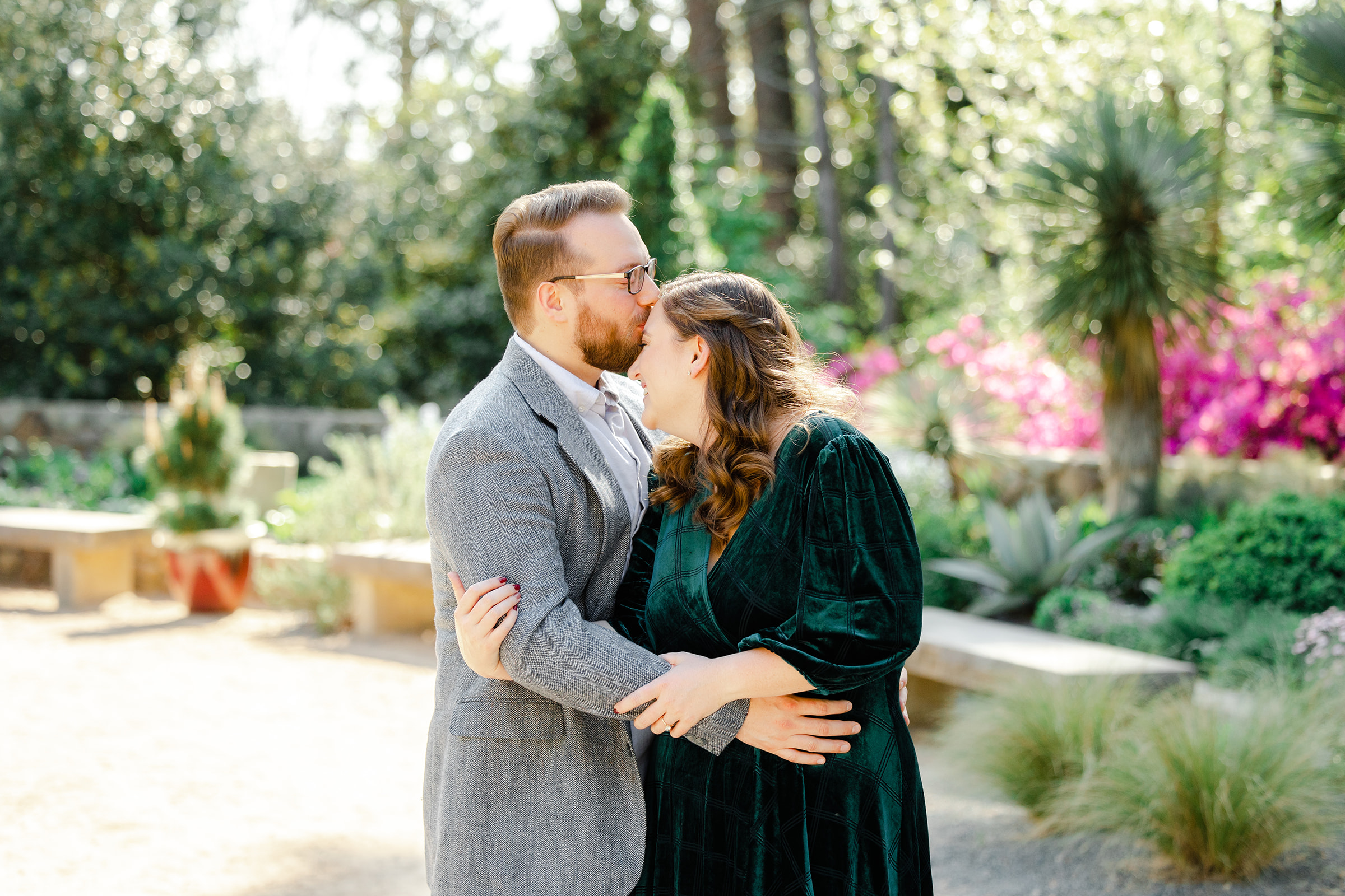 Couple kissing forehead at Duke Gardens for engagement session