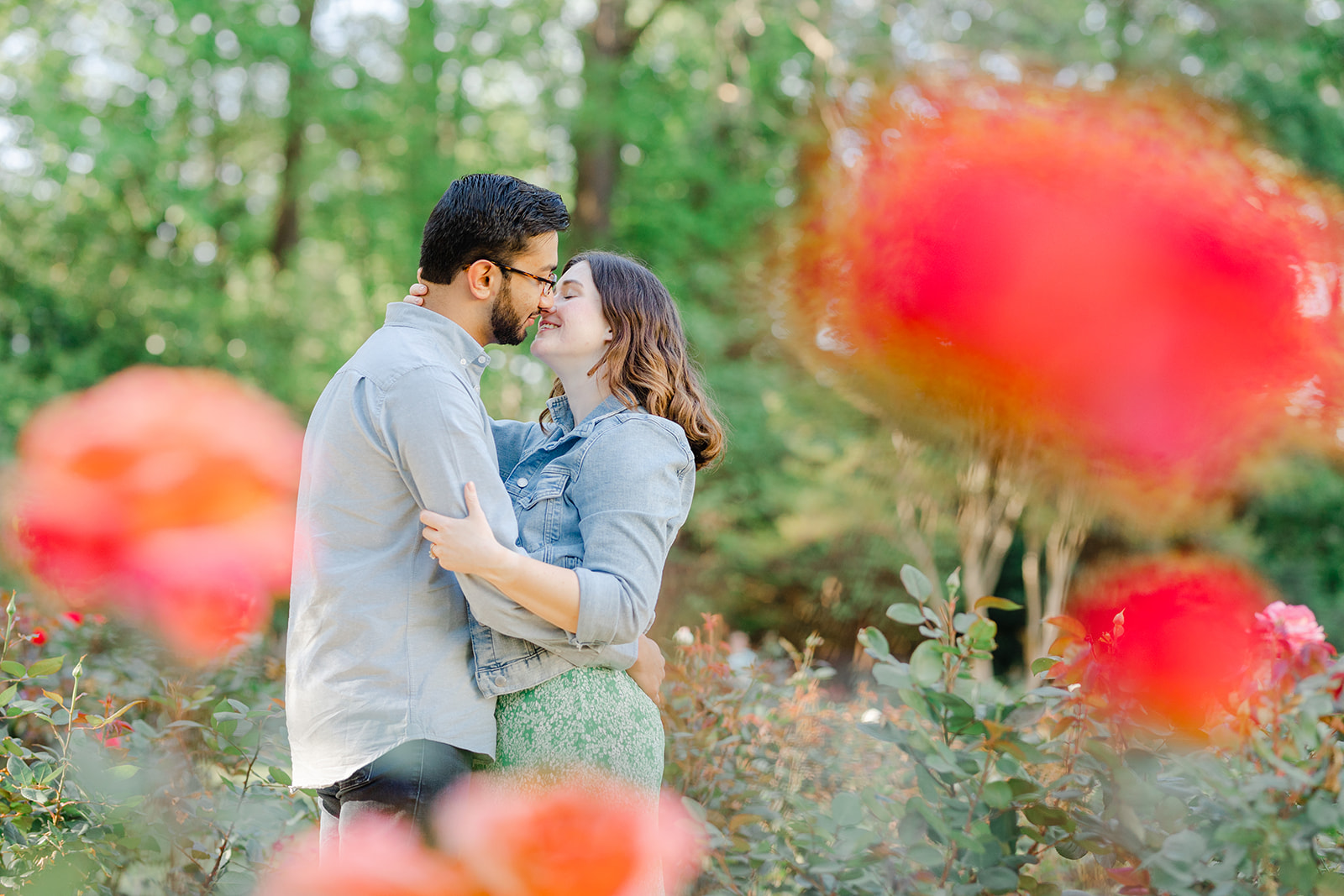 Couple hugging among the flowers in the Raleigh Rose Garden for their engagement session