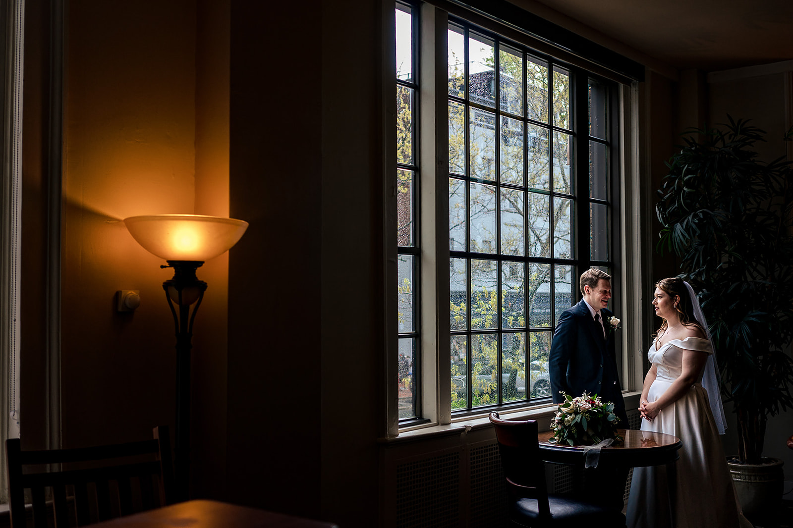 bride and groom having a moment aside a big window on their wedding day at Hotel Bethlehem 