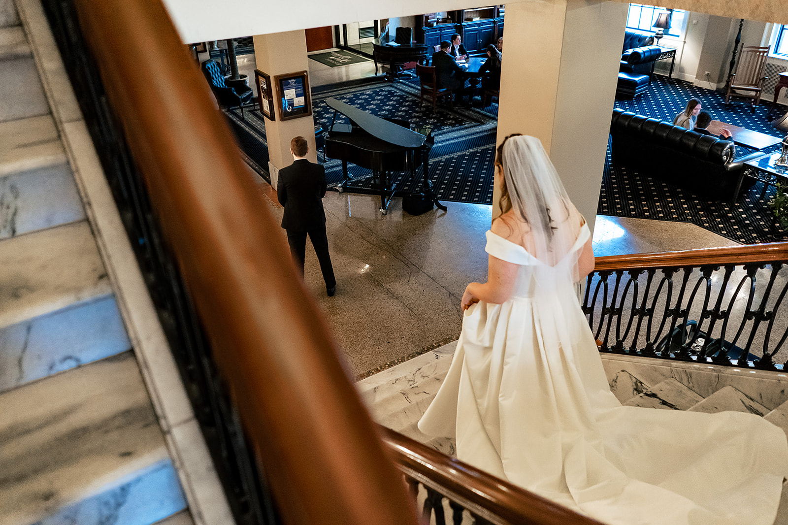 Bride walking down stairs to her groom during her First look in the lobby of Hotel Bethlehem
