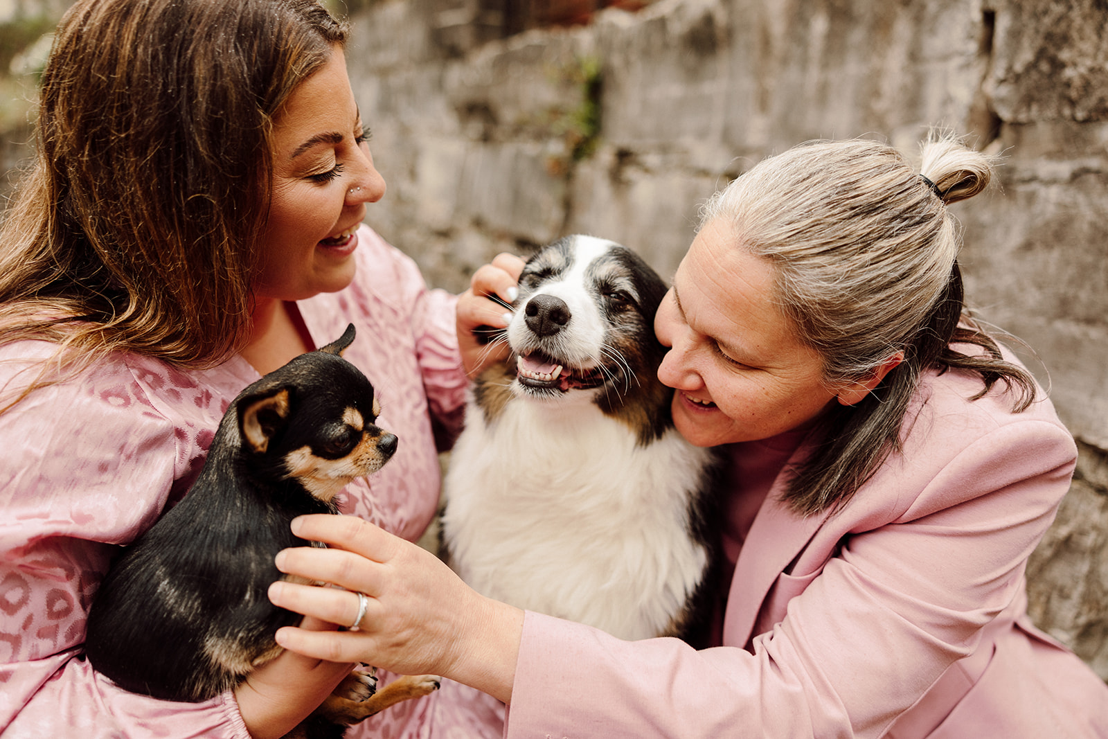 Women smiling and holding small dogs during their City Engagement Session