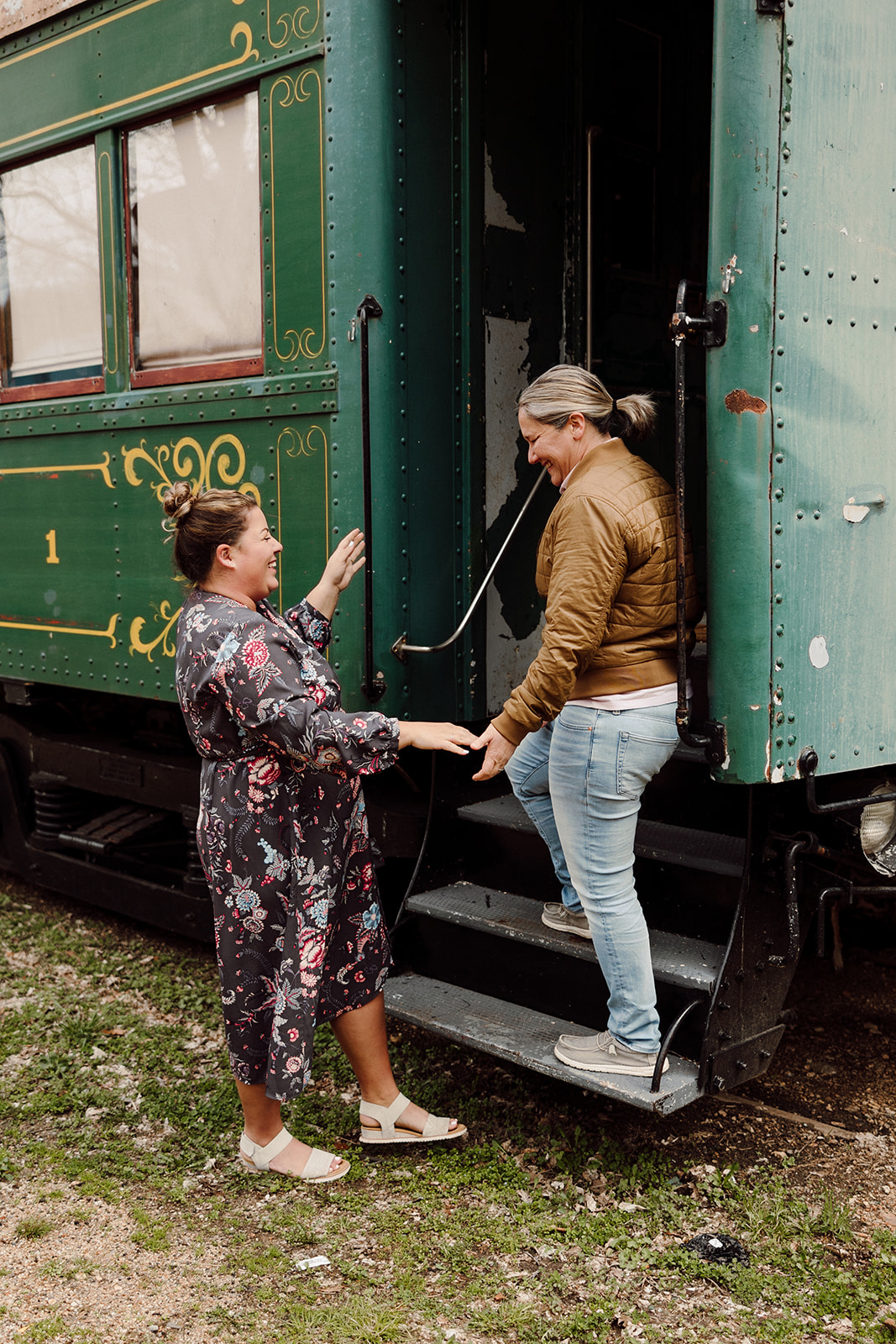 Women posing next to a train for their city engagement session