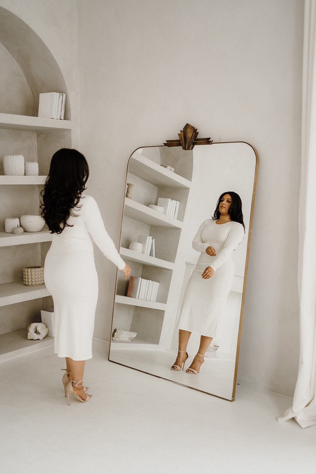 Lady standing in front of a mirror.