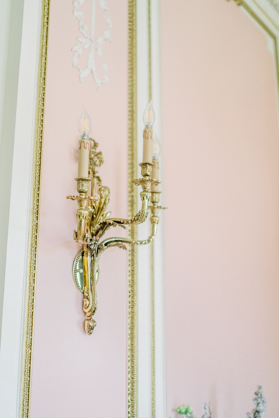 Gold brass antique candle lite on a pink wall at a destination wedding at Cairnwood Estate