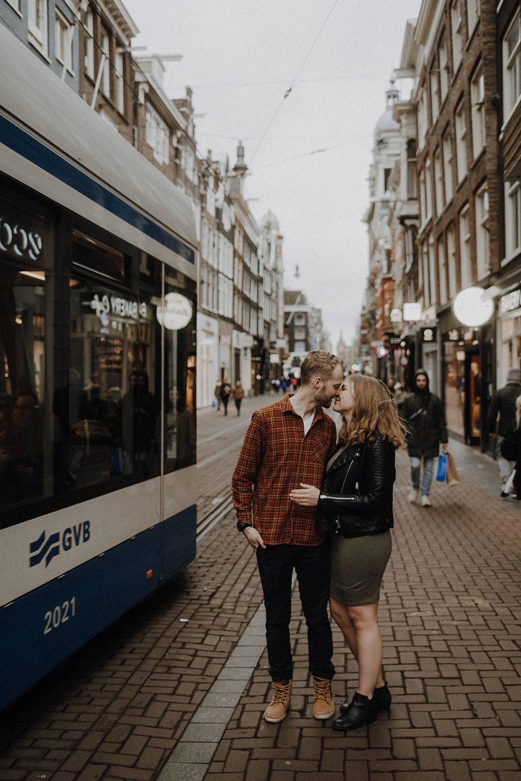 Amsterdam street car passes pregnant couple in spring maternity session