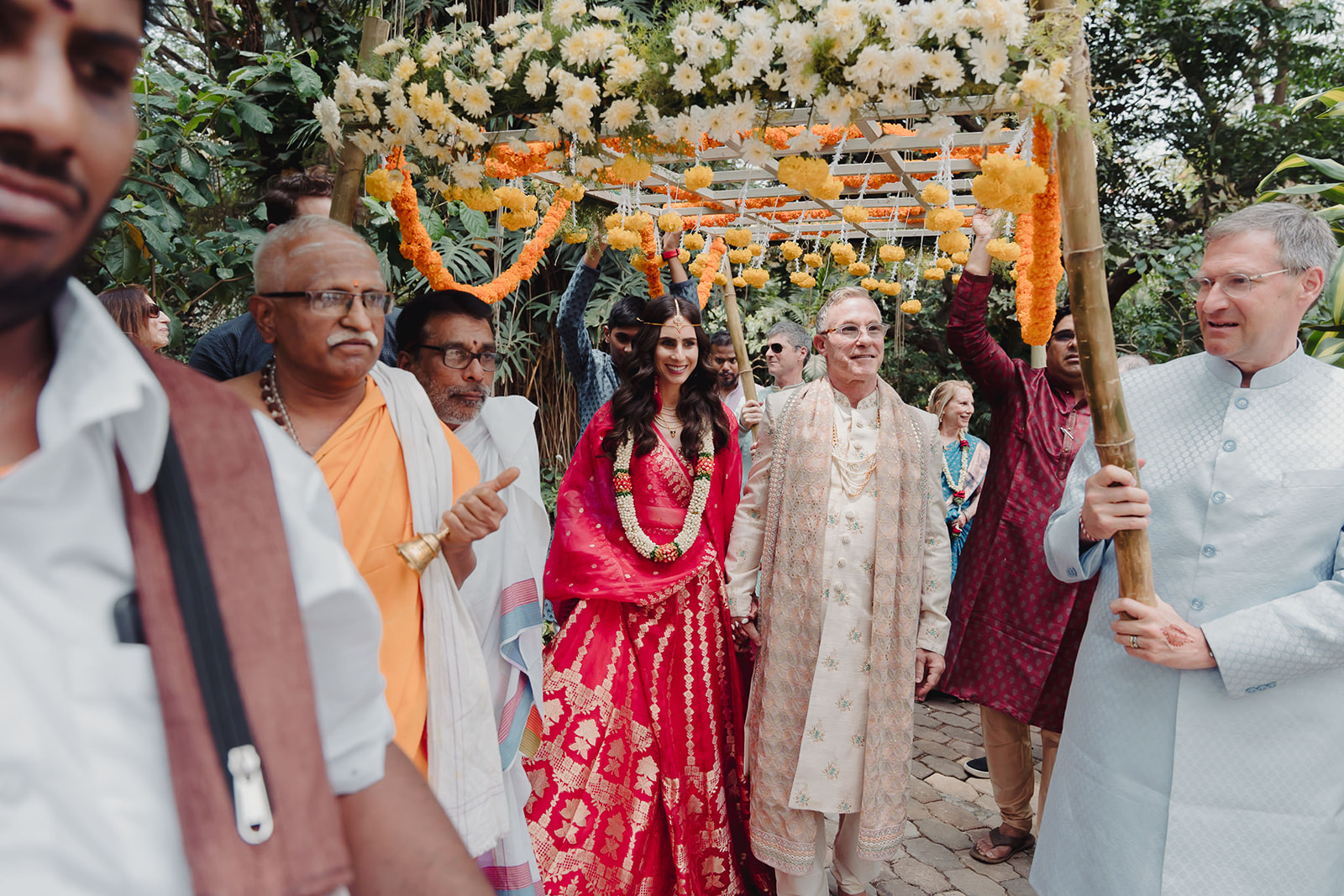 Bride accompanied by loved ones in mandap entry