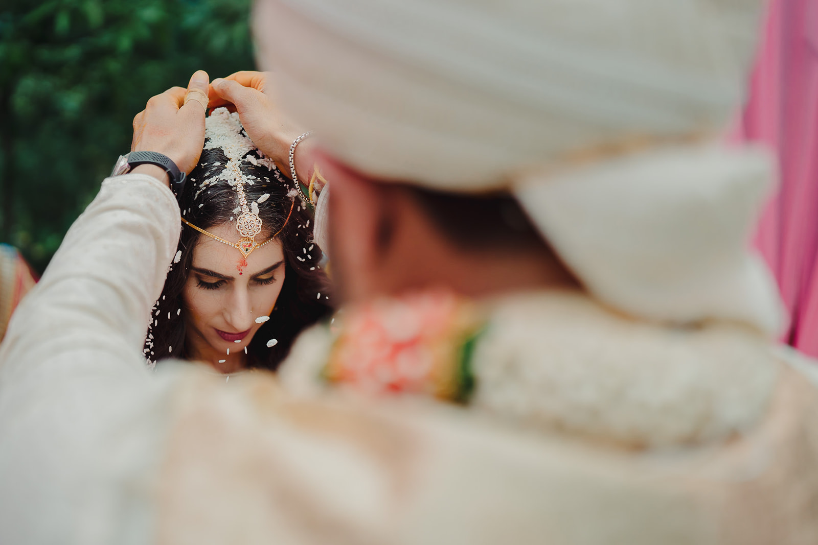 Groom gently places rice on bride's head
