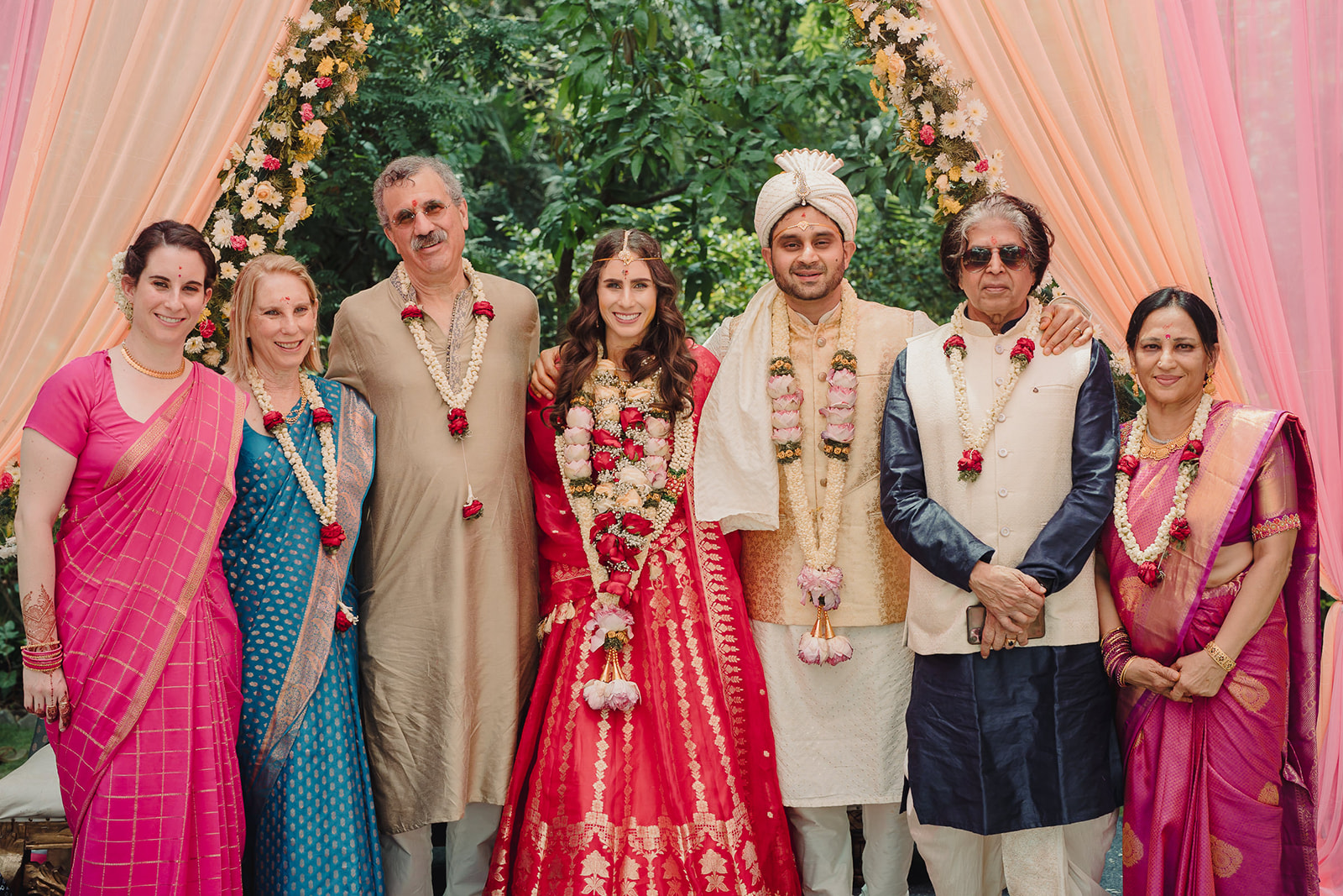 Bride and groom pose with their families for a heartwarming portrait