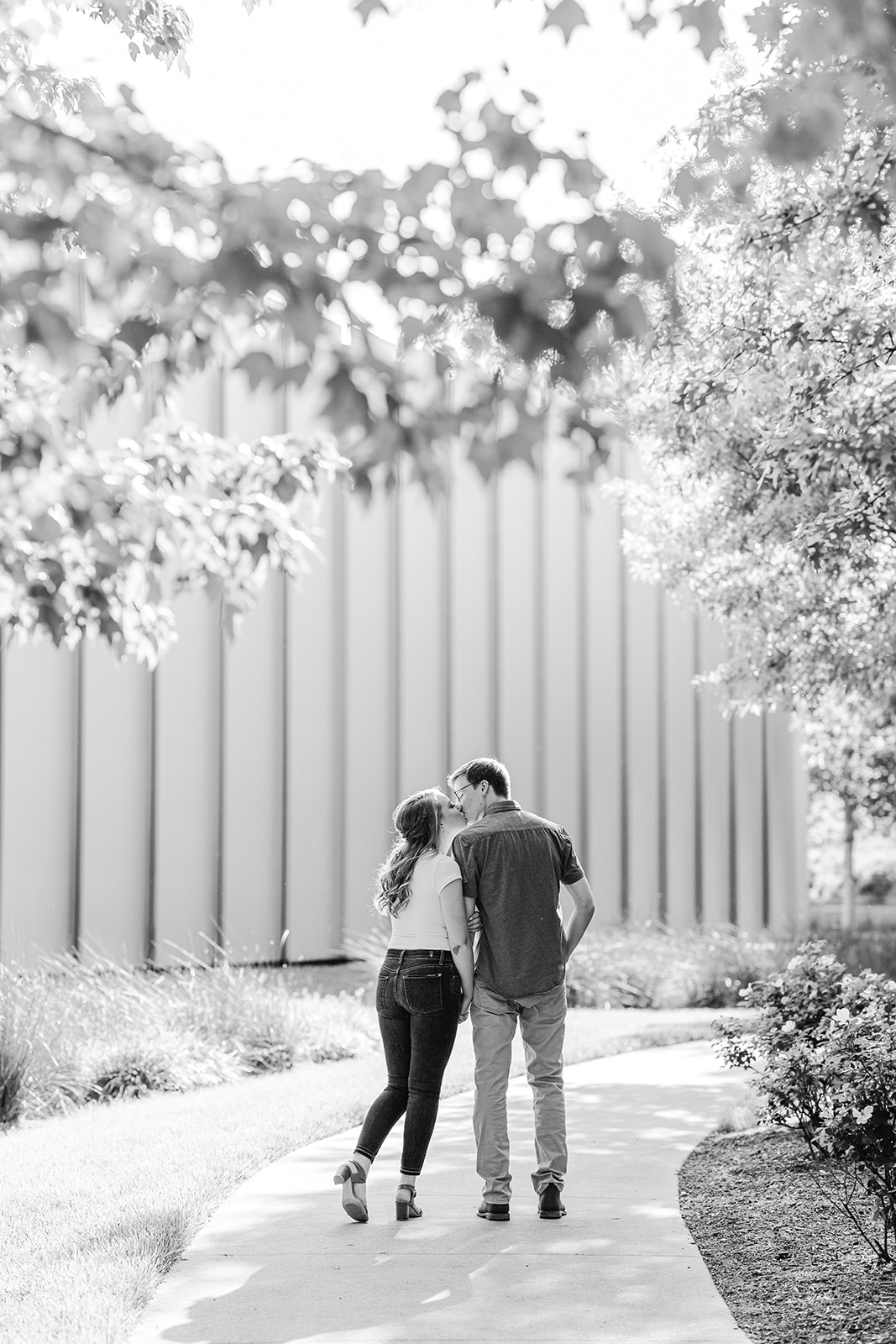 Couple kissing in front of the North Carolina Museum of Art in Raleigh for their spring engagement session
