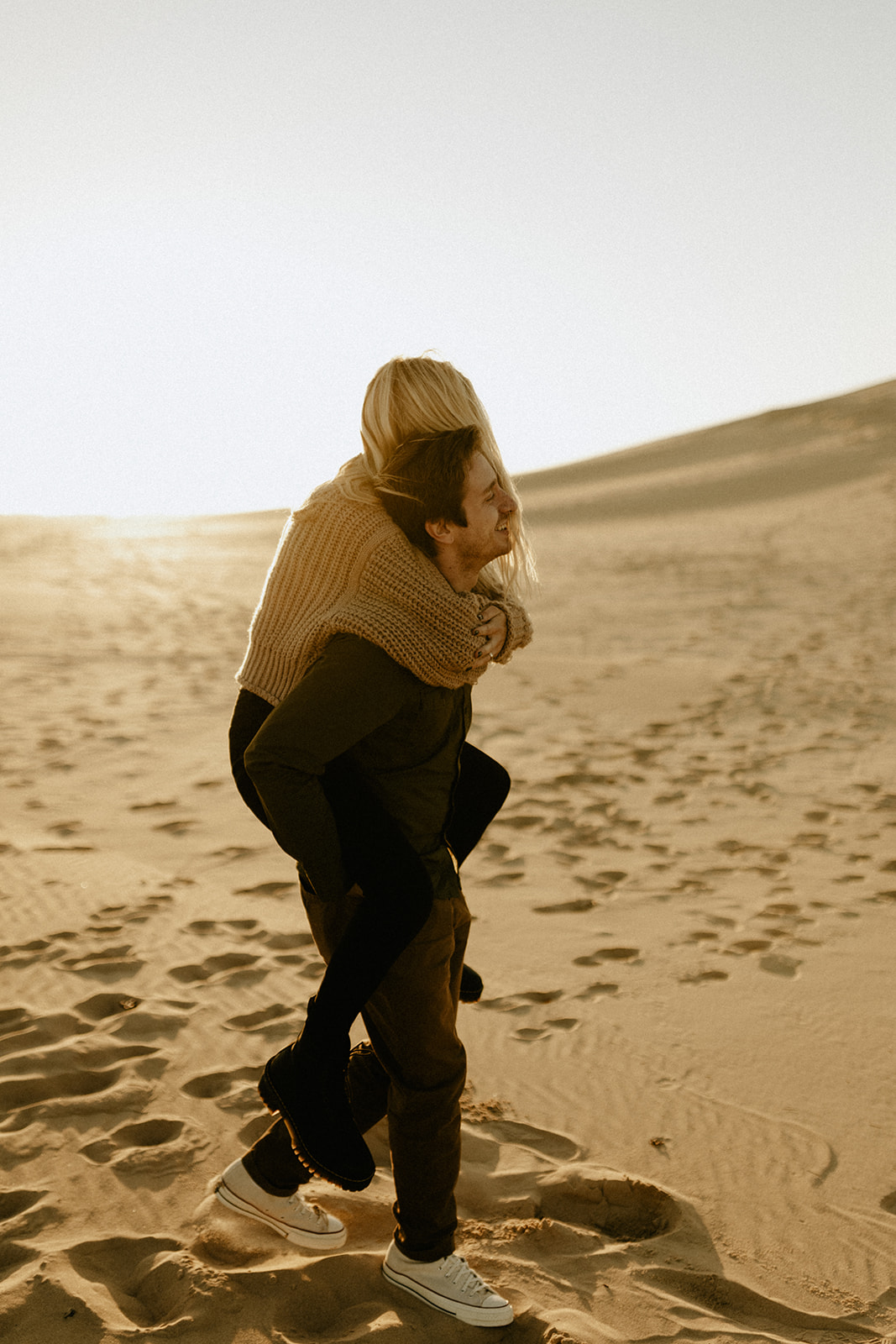 A couple's piggyback ride at Silver Lake Sand Dunes in Mears, Michigan