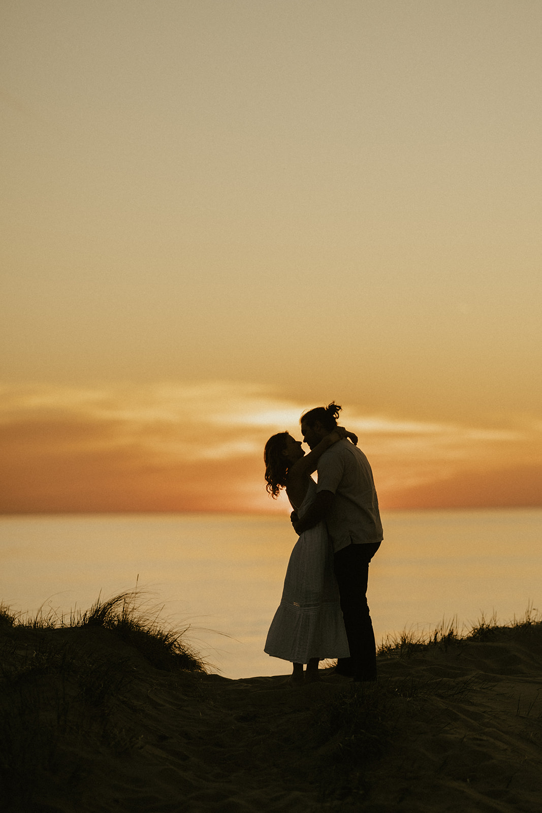 A silhouette of a couple hugging each other at sunset on Lake Michigan 