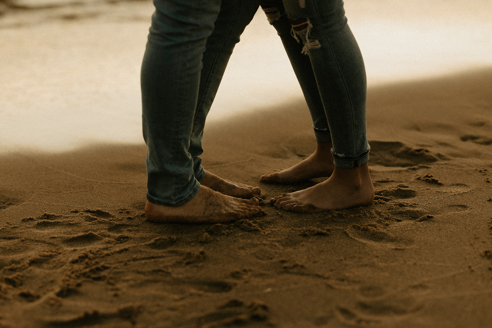 A couple's sandy feet on the beach 