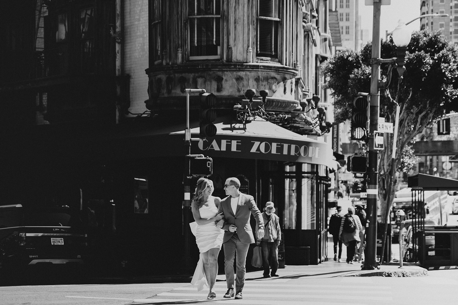 couple crosses the street at the Sentinel Building in San Francisco, featuring Cafe Zoetrope 