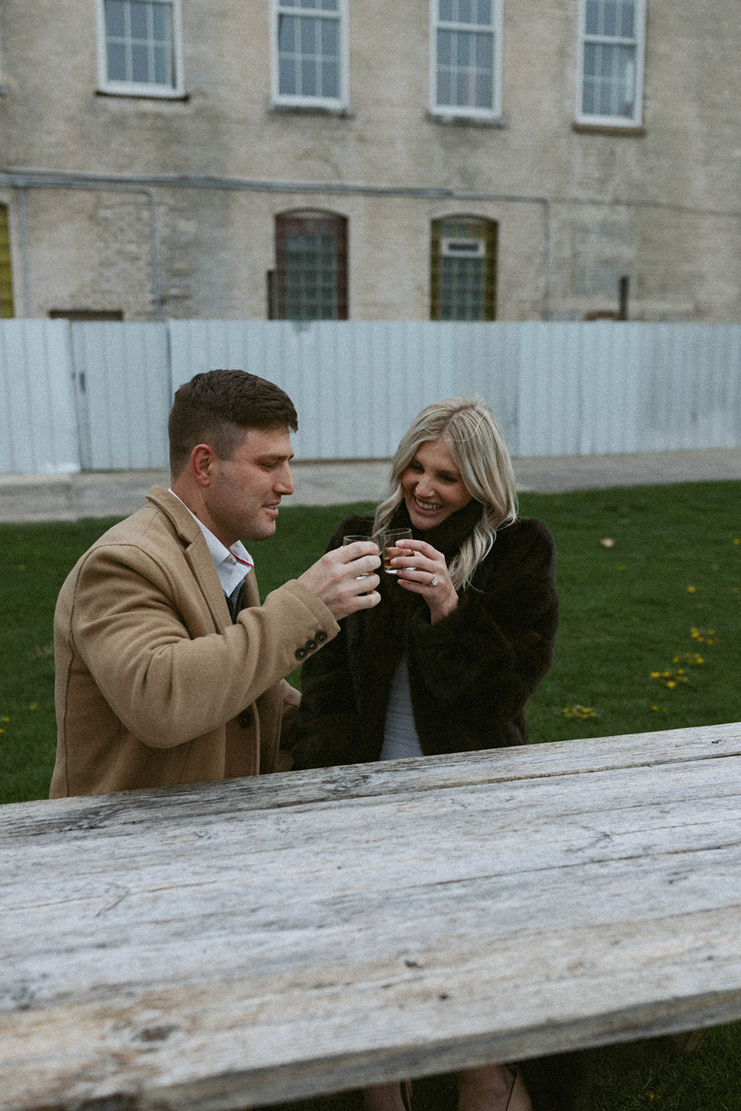 couple share a drink together outside journeyman distillery