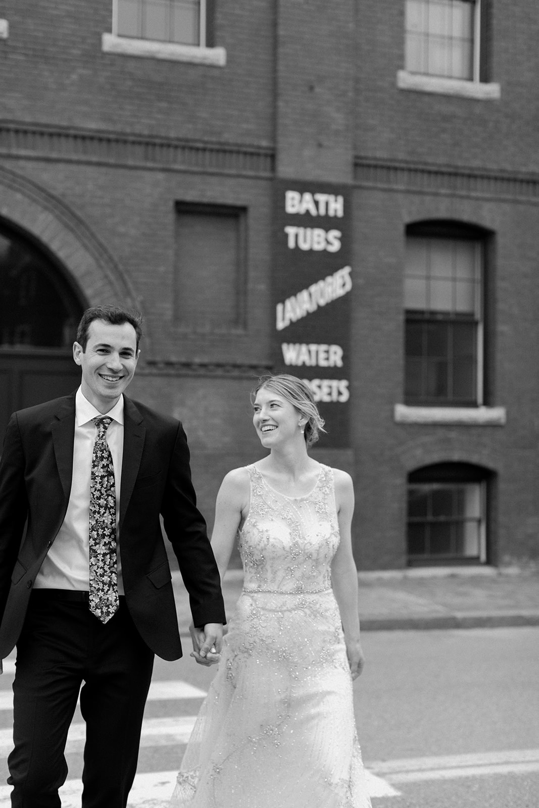 A bride and groom walk down the street in downtown Portland, Maine at their O'Maine Studios Wedding