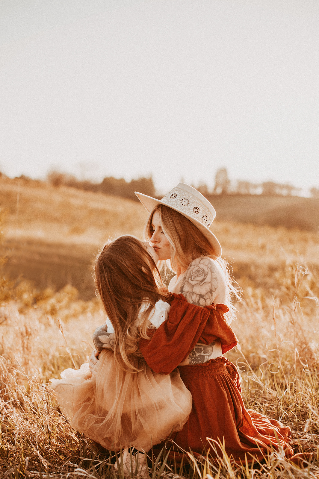Mother and daughter kiss in the field